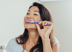 Woman brushing her teeth in bathroom