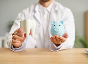 A dentist holding a model tooth