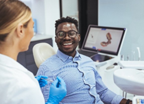 Man smiling at Brooklyn dentist during cosmetic dental consultation