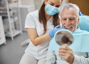 Brooklyn dentist showing patient their smile in small mirror