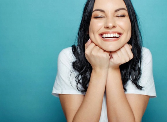 Smiling woman pleased with her dental crown in Brooklyn