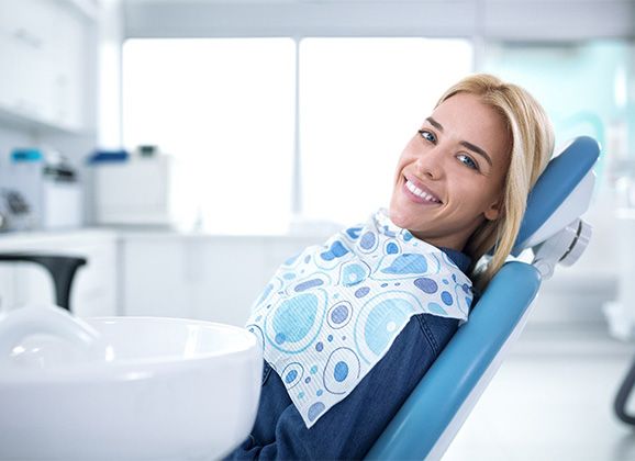 Woman with dental implants in Brooklyn smiling in treatment chair