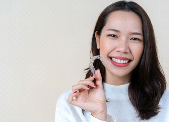 woman holding Invisalign on Ralph Avenue 