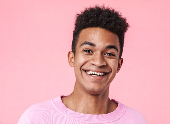 teen smiling with a sweater on during Invisalign treatment
