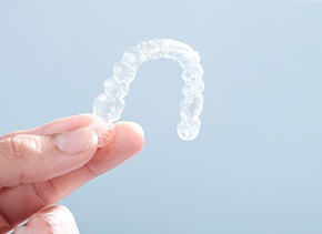 Patient holding up Invisalign aligner