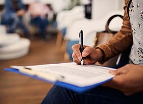 Patient filling out dental insurance information in office