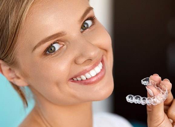 Woman holding an Invisalign tray