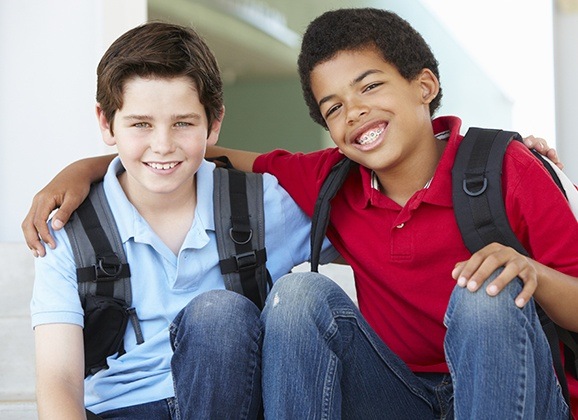Two kids smiling together after children's dentistry