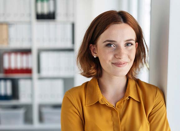 Portrait of young woman in orange shirt smiling