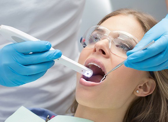 Dentist using intraoral camera to take a picture of patient's teeth