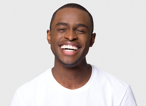 Man smiles after getting porcelain veneers in Brooklyn