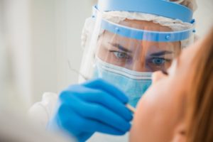 dentist in Brooklyn treating a patient wearing proper PPE 