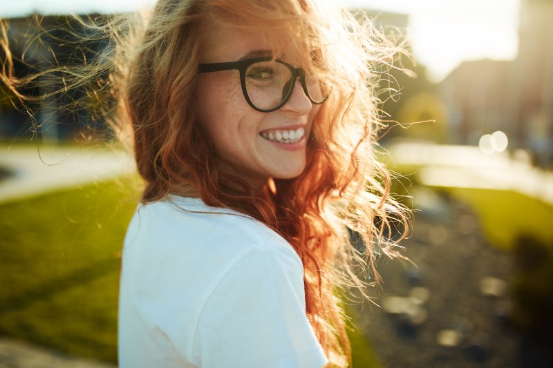 Closeup of woman with red hair smiling outside