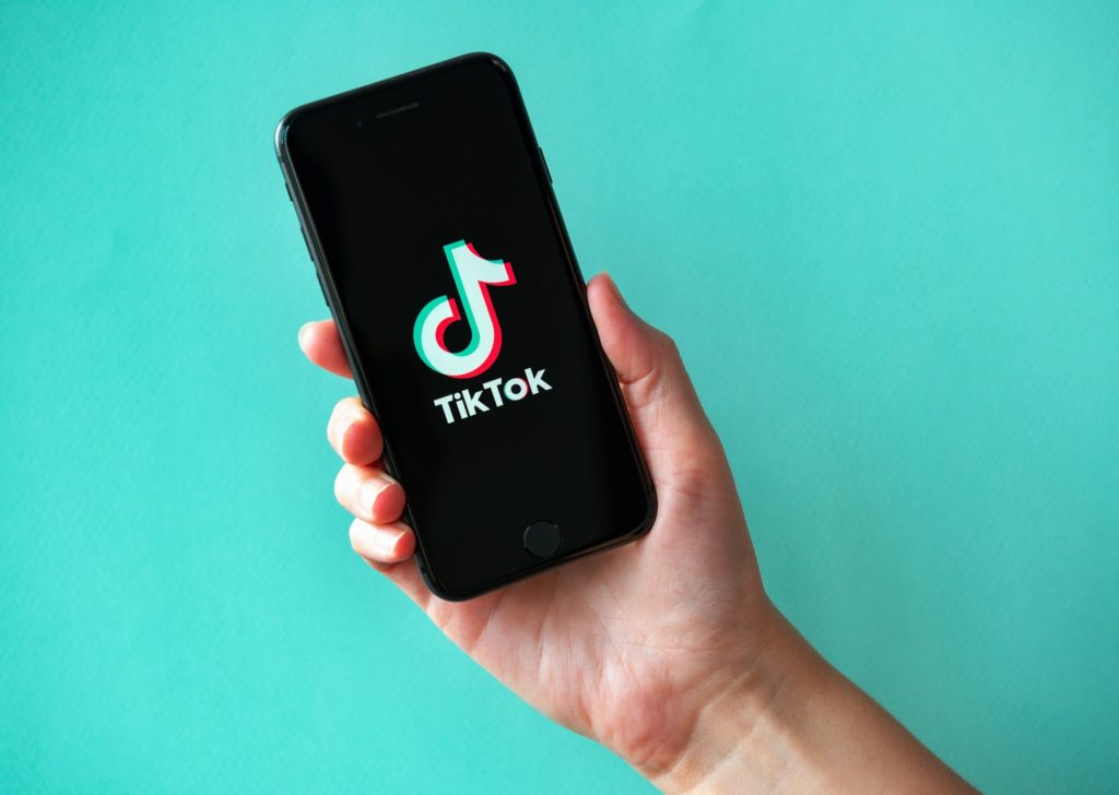 Person holding phone with TikTok app