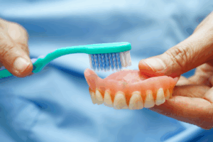 a close-up of a person brushing their dentures