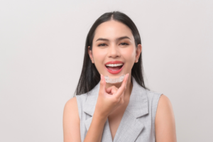 a patient holding their Invisalign aligner