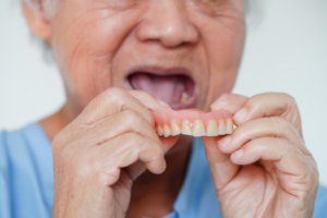 a patient holding their dentures
